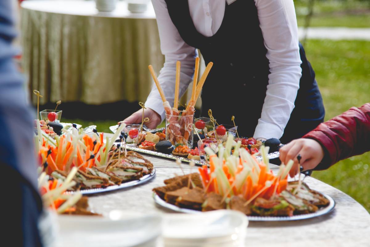 The waiter puts snacks on a buffet